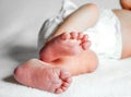 Small whiteskin newbork kid foot on white back Royalty Free Stock Photo