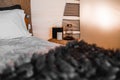 small wicker bedside table with tissue box lamp and candle in tent bedroom interior, tarawera, new zealand