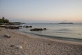 Small wild beach at sunset, beautiful natural scene, tranquil, calm water, travel destination, summer vacation, distant land