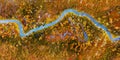 Small winding river in the yellow autumn forest aerial top view