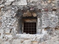 Small window with gride in stone wall Royalty Free Stock Photo