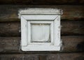 A small window in a rustic log house, curtained from the inside with a rag Royalty Free Stock Photo