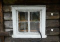 A small window in a rustic log house, curtained from the inside with a rag Royalty Free Stock Photo