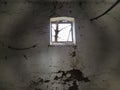 A small window at the top of the wall. Scary walls with cobwebs. Old church dormer. Halloween or haunted place. Prison cell with Royalty Free Stock Photo