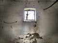 A small window at the top of the wall. Scary walls with cobwebs. Old church dormer. Halloween or haunted place. Prison cell with Royalty Free Stock Photo