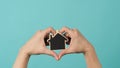 Small wood house in hands represent concepts such as home care family love Royalty Free Stock Photo