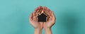 Small wood house in hands represent concepts such as home care family love Royalty Free Stock Photo