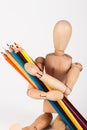 Small wood mannequin sitting with bunch of colour pencil isolate Royalty Free Stock Photo