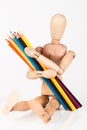 Small wood mannequin sitting with bunch of colour pencil isolate Royalty Free Stock Photo