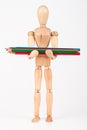 Small wood mannequin standing with bunch of colour pencil isolated on white