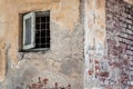 Small wooden barred window. Vintage picture with the worn out old brick wall of an abandoned building Royalty Free Stock Photo