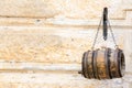 Small wooden barrel hanging on metal chains Royalty Free Stock Photo