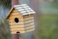 Small wooden bird house hanging on a tree branch outdoors Royalty Free Stock Photo