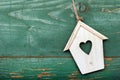 Small wooden bird house with heart decoration on green retro wooden background Royalty Free Stock Photo