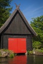 Small wooden boat house with red gate stands on the water in the town LÃÂ¼bbenau/Spreewald. Royalty Free Stock Photo