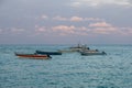 Small wooden boats, motorboats on ocean horizon in evening sun Royalty Free Stock Photo