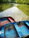 Small wooden boats with paddles on a lake with green mountains in the background Royalty Free Stock Photo