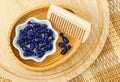 Small wooden bowl with cosmetic oil capsules eye or hair mask, face serum and wooden hair brush. Natural spa, skin or hair care Royalty Free Stock Photo