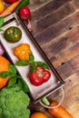 Small wooden box with color fresh ripe farm tomatoes and vegetables on old rustic table with copy space. Royalty Free Stock Photo