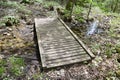 Small wooden bridge spanning forest stream along hiking trail at Nottawasaga Bluffs Royalty Free Stock Photo