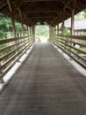 a small wooden bridge with a tiled roof to cross a small river