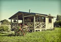 Wooden summer lodge with a flower bed Royalty Free Stock Photo