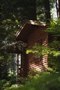 Small wooden cabin in the middle of a lush and dense forest, surrounded by trees in Okutama, Japan Royalty Free Stock Photo