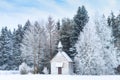 Small wooden chapel on snowbound frosty glade in snowy frozen forest Royalty Free Stock Photo