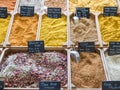 small wooden crates with various types of minced spices and grains: curcuma, curry, cajun, keufta, paprika and various infusions.