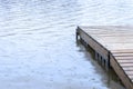 Small wooden dock leading out to a lake wet under heavy rainfall Royalty Free Stock Photo