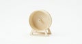 A small wooden hamster wheel with a minimalist design is centered against a plain Royalty Free Stock Photo