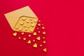 Small wooden hearts fly out of the envelope against a red background. Valentine`s Day. Love concept. Gift, message for lover. Cop Royalty Free Stock Photo