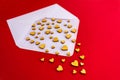 Small wooden hearts fly out of a white envelope on a red background. Valentine`s Day. Love concept. Royalty Free Stock Photo