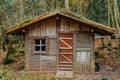 SMALL WOODEN HOUSE IN THE AUTUMN FOREST ON A CLOUDY DAY. SMALL WOODEN FARM BUILDING IN SCANDINAVIAN STYLE Royalty Free Stock Photo