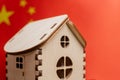 Small wooden house, China flag on background. Real estate concept, soft focus Royalty Free Stock Photo