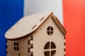 Small wooden house, France flag on background. Real estate concept, soft focus Royalty Free Stock Photo