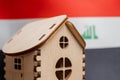 Small wooden house, Iraq flag on background. Real estate concept, soft focus Royalty Free Stock Photo