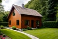 A small wooden house in the middle of a lush green yard, simple gable roofs.