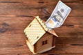 A small wooden house-piggy bank and a money bill of 100 dollars Royalty Free Stock Photo