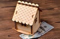 A small wooden house-piggy bank and a money bill of 100 dollars Royalty Free Stock Photo