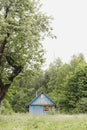 Small wooden house in rural field, view on a farmhouse in countryside, summer scenic landscape Royalty Free Stock Photo