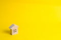 A small wooden house stands on a yellow background. The concept of buying and selling real estate, renting. Search for a house. Af Royalty Free Stock Photo