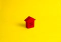 A small wooden house stands on a yellow background. The concept Royalty Free Stock Photo