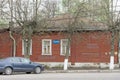 A small wooden house in an unknown village with a blue sign on which is written GAZPROM LLC.
