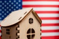 Small wooden house, USA flag on background. Real estate concept, soft focus Royalty Free Stock Photo