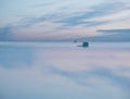 A small wooden house on the water`s edge with the reflection of the sky in the water. Royalty Free Stock Photo