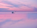 A small wooden house on the water`s edge with the reflection of the sky in the water. Royalty Free Stock Photo