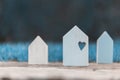 Small wooden houses with a heart on the big one symbolizing family love and security at home Royalty Free Stock Photo