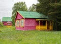 Small wooden houses for tourists stand in the garden in a blooming meadow among the trees on a summer day