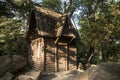 A small wooden hut with carved frames among the rocks in the forest. Fairytale house. Royalty Free Stock Photo